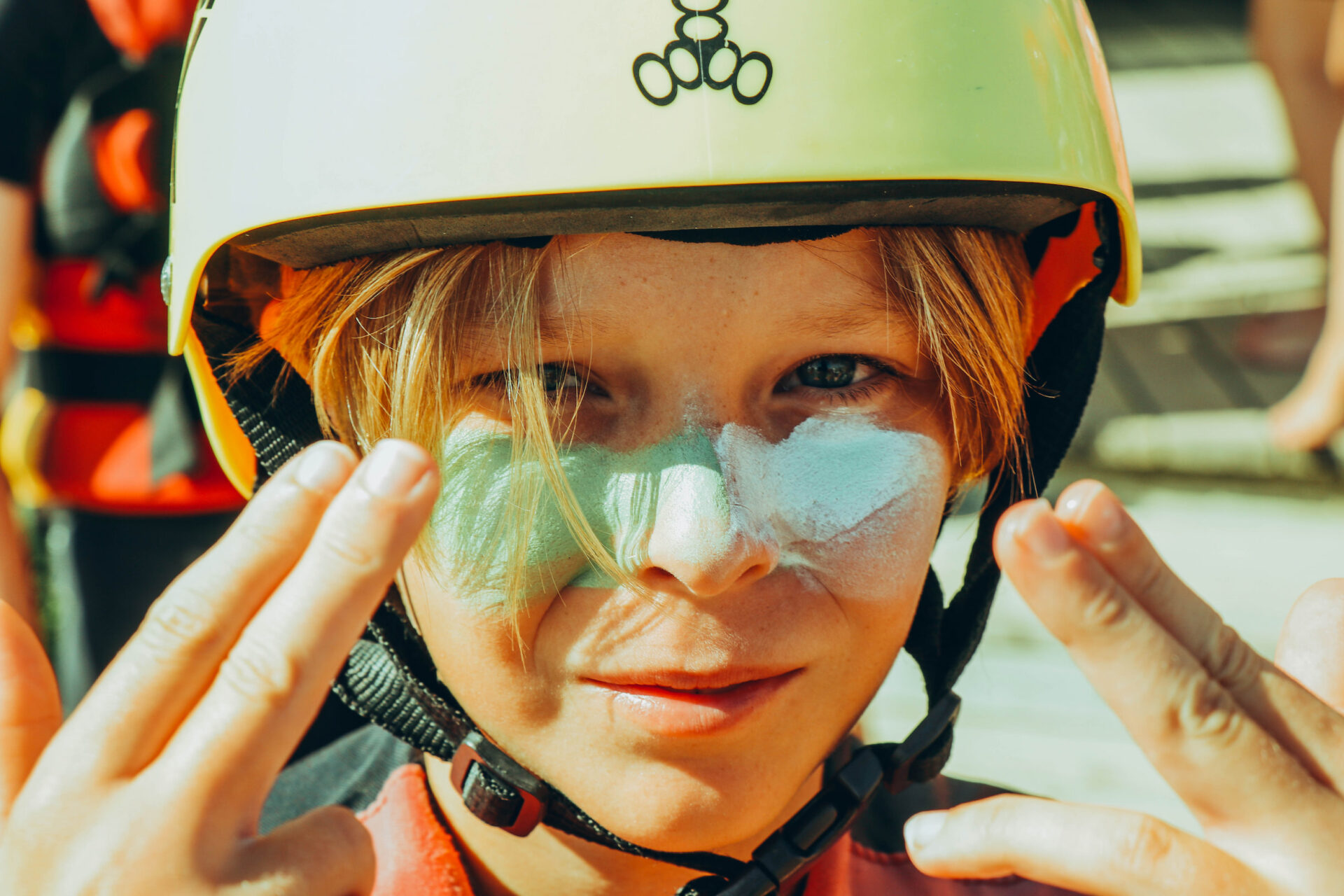 Jeune participant au visage strié de crème solaire